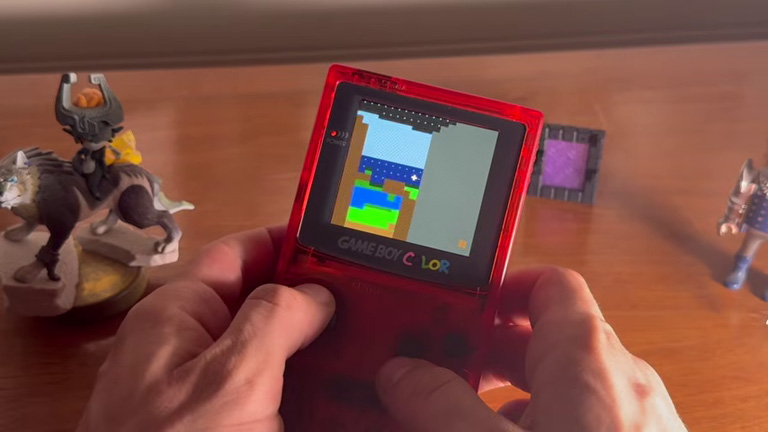 Minecraft tournant sur une Game Boy Color rouge au-dessus d'une table avec un amiibo Twilight Princess
