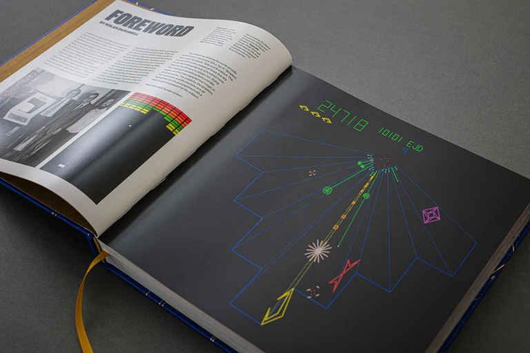 Le livre The Arcade 1971–1999: The Stories Behind Classic Coin-Ops, Told by Their Creators, ouvert à la préface de Nolan Bushnell avec une capture d'écran de Tempest en pleine page